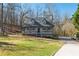 Charming two-story home featuring a cozy front porch, grey siding, and a well-manicured lawn surrounded by mature trees at 504 Hanover Ct, Woodstock, GA 30188