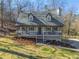 Charming home featuring a cozy front porch, grey siding, dormer windows and a well-manicured lawn surrounded by mature trees at 504 Hanover Ct, Woodstock, GA 30188