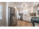 Well-lit kitchen with stainless steel appliances, white cabinets, granite countertops, and light wood-look flooring at 504 Hanover Ct, Woodstock, GA 30188