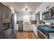 Modern kitchen with stainless steel appliances, white cabinets, granite countertops, and light wood-look flooring at 504 Hanover Ct, Woodstock, GA 30188
