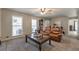 Inviting living room with neutral walls and carpet, featuring a large window, ceiling fan, and comfortable brown leather sofa at 504 Hanover Ct, Woodstock, GA 30188