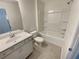 Bright bathroom featuring a shower-tub, single sink vanity, and neutral tile flooring at 272 Laurel Canyon Pkwy, Canton, GA 30114