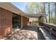 Exterior of a brick home with an expansive deck, perfect for outdoor entertaining and enjoying the wooded scenery at 4693 Sugar Hill Se Rd, Acworth, GA 30102