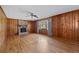 Bright living room featuring hardwood floors, wood paneling, and a cozy brick fireplace at 4693 Sugar Hill Se Rd, Acworth, GA 30102