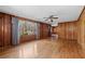 Spacious living room featuring hardwood floors, wood paneling, and a large window at 4693 Sugar Hill Se Rd, Acworth, GA 30102