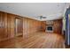 Spacious living room features wood paneling, hardwood floors, and a brick fireplace at 4693 Sugar Hill Se Rd, Acworth, GA 30102