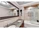 Elegant bathroom featuring double sinks, granite countertops and decorative tilework in shower and around large decorative mirror at 515 Butler National Dr, Johns Creek, GA 30097