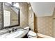 Powder room with granite vanity, designer mirror, and patterned wallpaper at 515 Butler National Dr, Johns Creek, GA 30097