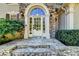 Close-up of the elegant front door with stone surround, decorative glass, and stone steps at 515 Butler National Dr, Johns Creek, GA 30097