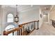 Upstairs hallway featuring wood and iron railing, chandelier, and great natural light at 515 Butler National Dr, Johns Creek, GA 30097