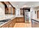 Modern kitchen with granite countertops, stainless steel appliances, and wood cabinets at 515 Butler National Dr, Johns Creek, GA 30097
