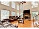 Spacious living room with fireplace, soaring ceilings, and a wall of bright windows at 515 Butler National Dr, Johns Creek, GA 30097
