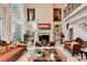 Bright and airy living room with two-story windows, a fireplace, and beautiful built-in shelving at 515 Butler National Dr, Johns Creek, GA 30097