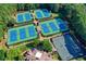Aerial view of community tennis courts surrounded by mature trees in a well-maintained neighborhood at 515 Butler National Dr, Johns Creek, GA 30097