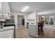 Open kitchen with stainless steel appliances and view to living area with hardwood floor at 3130 Goldmist Dr, Buford, GA 30519
