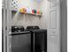 Laundry room equipped with gray front-load washer and dryer, and overhead shelving at 3130 Goldmist Dr, Buford, GA 30519