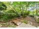 Idyllic backyard featuring a bridge, trees, and a stone path for relaxing outdoor enjoyment at 4022 Newhaven Cir, Brookhaven, GA 30319