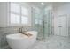 Bright and airy bathroom featuring soaking tub, large glass shower, and white marble floors at 4022 Newhaven Cir, Brookhaven, GA 30319