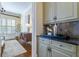 Butler pantry with tiled backsplash, cabinets, and shelving, connecting to dining room at 4022 Newhaven Cir, Brookhaven, GA 30319