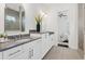 Modern bathroom featuring double vanity, stone countertops, white cabinets, an arched mirror and an open door to the bedroom at 261 Thompson St, Alpharetta, GA 30009