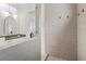 Bathroom featuring gray tiled walls, a decorative mirror, sink, and a shower at 261 Thompson St, Alpharetta, GA 30009