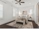 Bright bedroom featuring a ceiling fan, plantation shutters, and neutral decor with a door to an ensuite bath at 261 Thompson St, Alpharetta, GA 30009