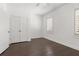 Empty bedroom featuring hardwood floors, white walls and trim and a window with blinds at 261 Thompson St, Alpharetta, GA 30009