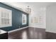 Well-lit bedroom featuring elegant dark wood floors, three windows with shutter-style blinds, and light fixtures at 261 Thompson St, Alpharetta, GA 30009