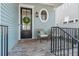 Cozy front porch seating area with black door, wreath, and oval window at 261 Thompson St, Alpharetta, GA 30009