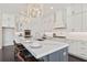 Modern kitchen boasts white cabinets, stainless steel appliances, marble countertops and oversized island with seating at 261 Thompson St, Alpharetta, GA 30009