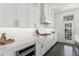 Stylish kitchen featuring white cabinets, stainless steel appliances, and stone countertops, with a door to the outside at 261 Thompson St, Alpharetta, GA 30009