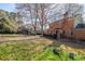 View of the home's backyard including a playset, lush green grass, and a brick home at 4210 Gladney Dr, Atlanta, GA 30340