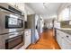 Modern kitchen featuring stainless steel appliances, white cabinetry, and hardwood floors at 4210 Gladney Dr, Atlanta, GA 30340
