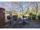 A patio area with an outdoor table set, grill, brick column, and green shrubbery at 4210 Gladney Dr, Atlanta, GA 30340