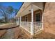 View of the home's brick-columned front porch with white railings at 4210 Gladney Dr, Atlanta, GA 30340