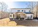 Exterior view of the back of the home featuring a covered patio and spacious backyard at 1200 Primrose Park Rd, Sugar Hill, GA 30518