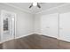 Bedroom features wood floors, bathroom access, and a ceiling fan at 1200 Primrose Park Rd, Sugar Hill, GA 30518