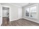 This is a bedroom featuring hardwood floors, a window with plantation shutters and white trim at 1200 Primrose Park Rd, Sugar Hill, GA 30518