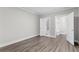 This bedroom features hardwood floors and two open doorways to a bathroom and closet at 1200 Primrose Park Rd, Sugar Hill, GA 30518