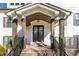 Close-up of a covered brick porch with dark wood columns and front door, offering a welcoming entrance at 1200 Primrose Park Rd, Sugar Hill, GA 30518