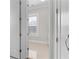 Hallway view offers a glimpse into a naturally lit bathroom with tiled floors at 1200 Primrose Park Rd, Sugar Hill, GA 30518