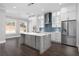 A modern white kitchen with stainless steel appliances, a center island, and a blue backsplash at 1200 Primrose Park Rd, Sugar Hill, GA 30518