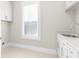 Bright laundry room with white cabinets, countertops, and a stainless steel sink at 1200 Primrose Park Rd, Sugar Hill, GA 30518
