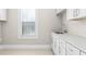 Laundry room offers white cabinets, countertops, and a stainless steel sink at 1200 Primrose Park Rd, Sugar Hill, GA 30518
