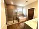 Modern bathroom featuring a glass-enclosed shower, soaking tub, and stylish vanity with wood-look flooring at 125 Laurel Farms Ln, Dallas, GA 30157
