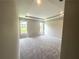 A spacious bedroom featuring plush carpet, a tray ceiling, and large windows for natural light at 125 Laurel Farms Ln, Dallas, GA 30157