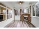 Inviting sunroom featuring a brick fireplace, wood-look flooring, and an abundance of natural light through large windows at 2733 Caldwell Rd, Brookhaven, GA 30319