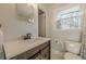 Bright bathroom with a wood vanity, white countertop, and a window providing natural light at 2736 Old Norcross Rd, Tucker, GA 30084