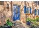 Inviting blue front door with decorative glass, flower boxes, and brick facade, adding to the home's curb appeal at 2736 Old Norcross Rd, Tucker, GA 30084