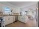 Well-lit kitchen with white cabinets, tile floors and stainless steel appliances, with a view of the dining area at 2736 Old Norcross Rd, Tucker, GA 30084